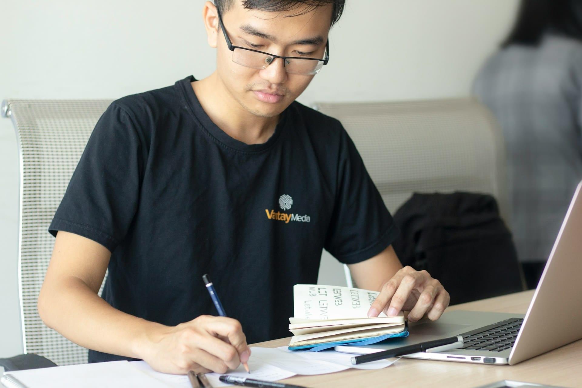 Студент делает записи по программированию в тетрадь